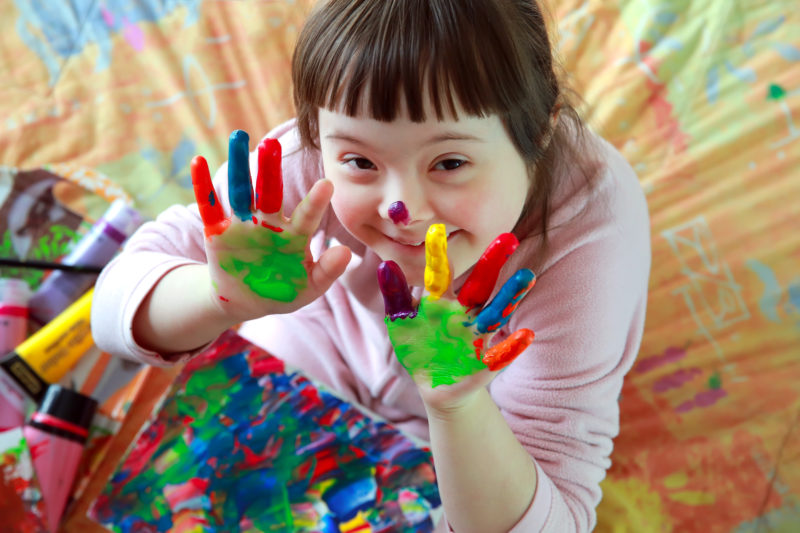little girl in tutu covered in finger paint