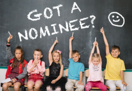 children sitting in front of chalkboard with words "got a nominee"