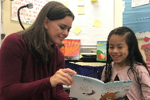 adult reading with elementary student