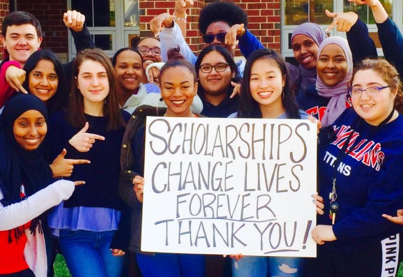 Scholarship Recipients holding sign saying "Scholarships change lives. Thank you!"