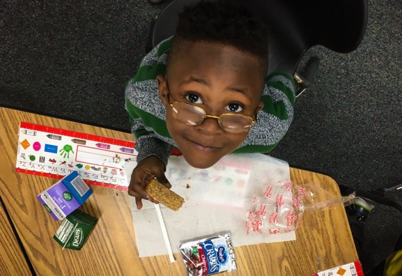 kindergarten student eating breakfast in the classroom'