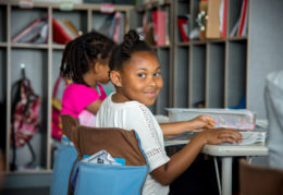 Smiling female elementary student at her desk