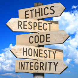 Directional signs on one post: ethics, respect, code, honesty, integrity