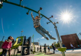 boy on monkey bars and bright blue sky