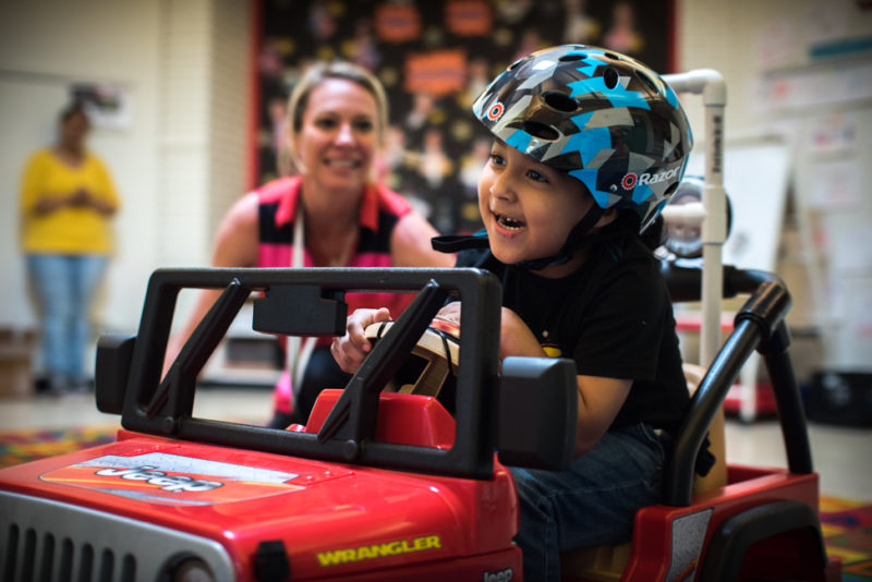 A Barrett student getting to know his new motorized car
