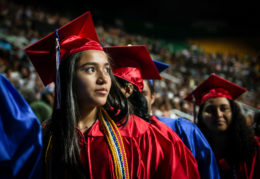female graduate looks out across the crowd of the arena