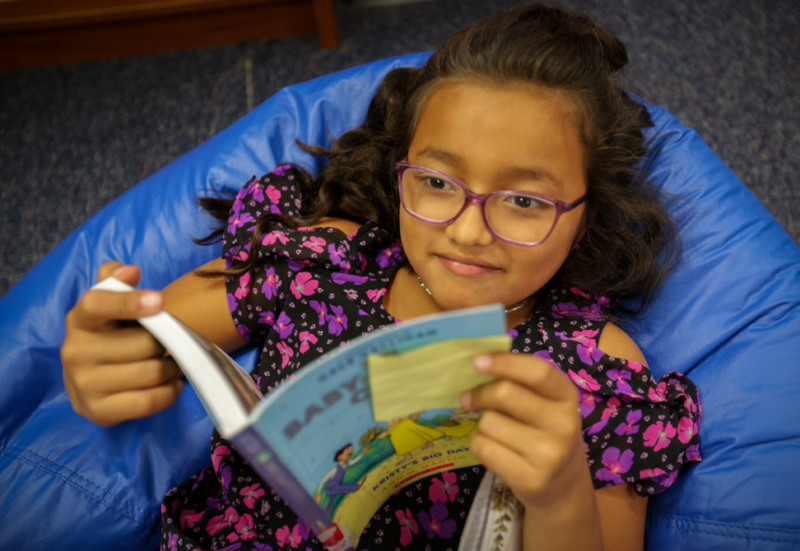 a young girl reads a book on a bean bag in John Adams' library