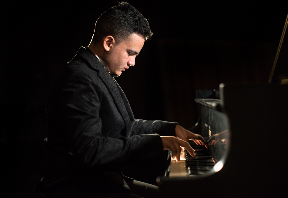 jonathan flores plays a grand piano on stage