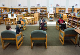students reading books and using computer at GWMS library