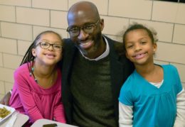 dad having lunch with daughters in school