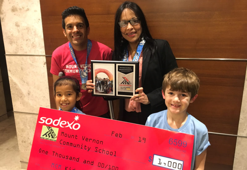 Children holding a giant check for $1000