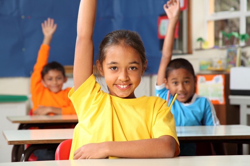Girl in classrom raising hand