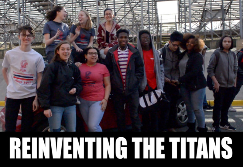 tc students on top of car behind bleachers