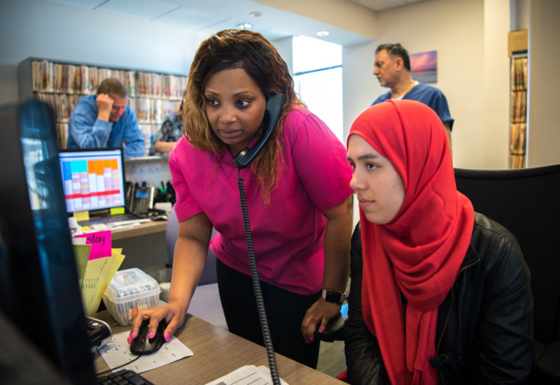 Shafiqa Omarkhil working the desk at Bradlee Dental with mentor Sechelle Cause