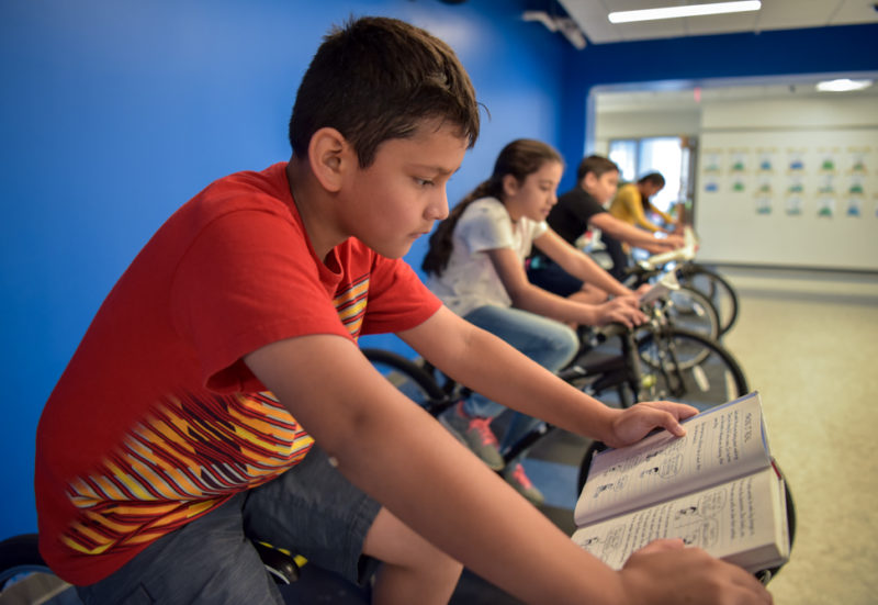 students read on fleet of stationary bikes