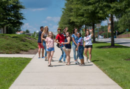 students walking on the sidewalk in front of TC Williams