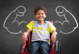 young boy in wheel chair with muscle arms