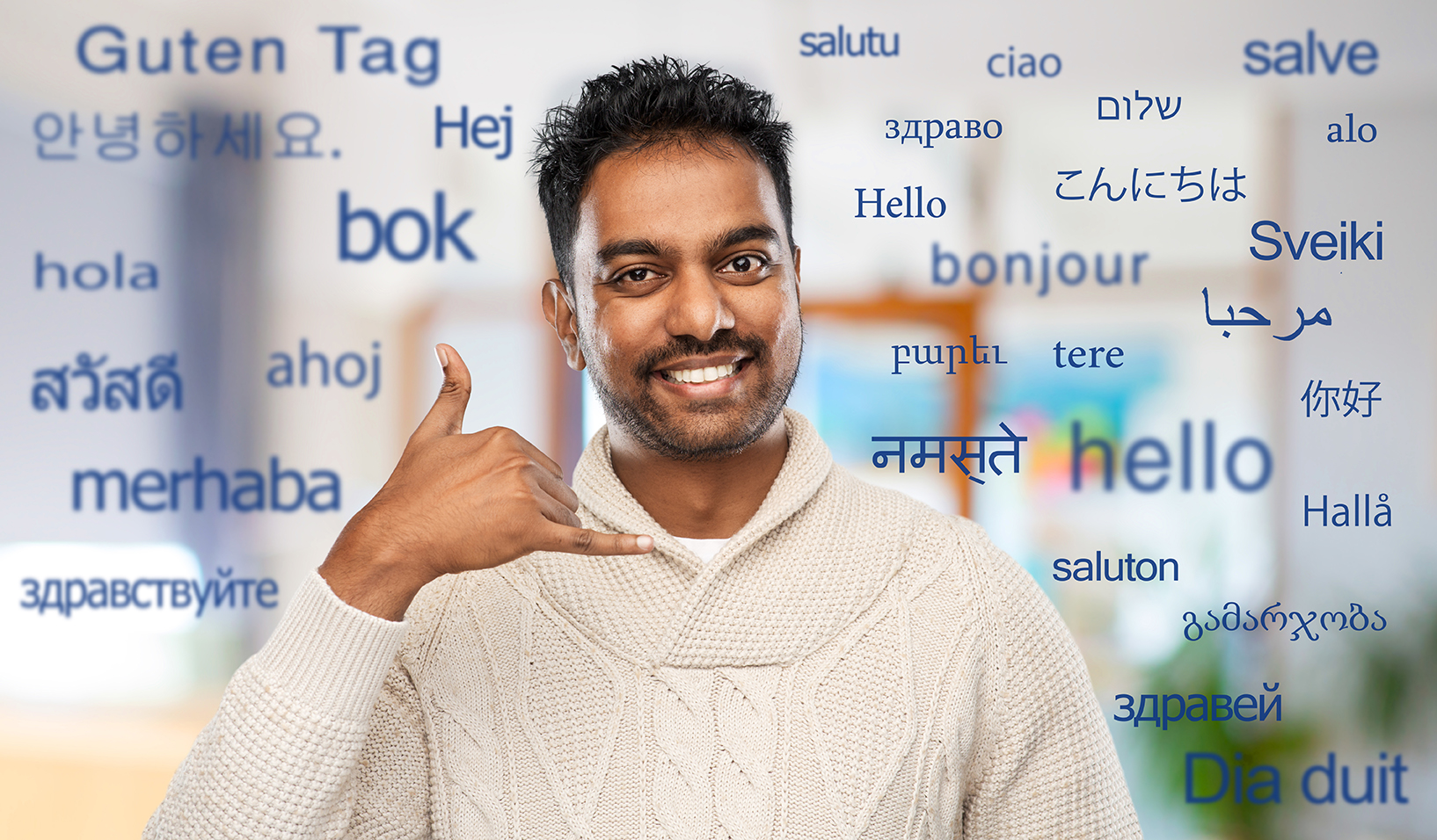 man in sweater making phone call gesture