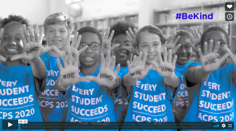 middle school students with hands extended with the words "be kind" written on them