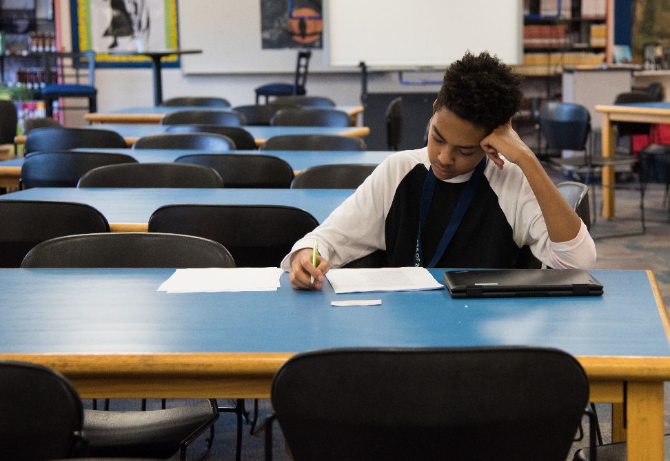 Male student working at desk in school