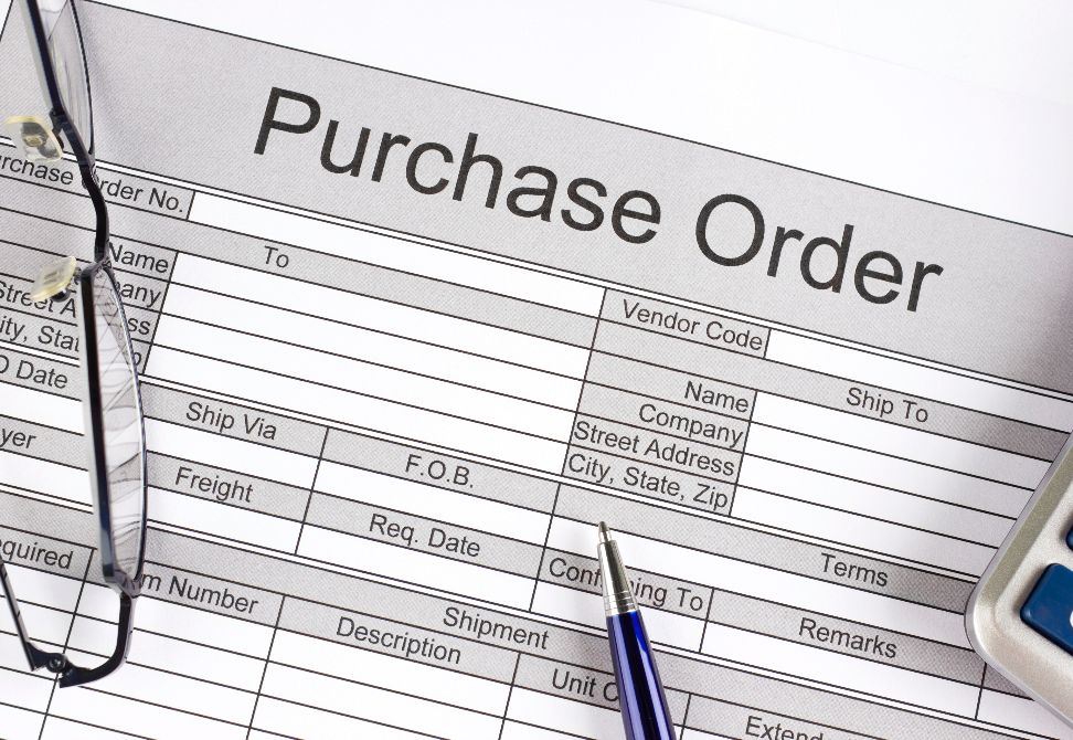purchase order, glasses, pen and calculator