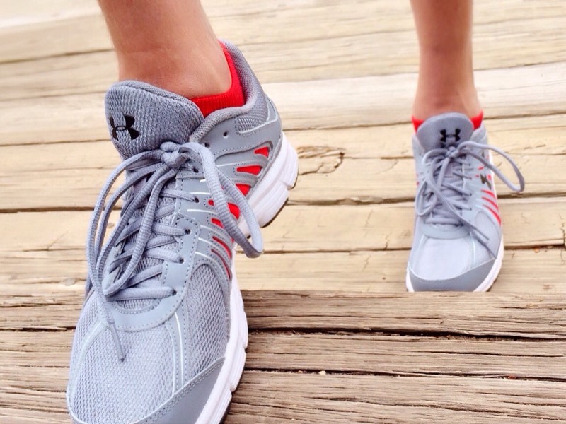 Feet in running shoes going up wooden stairs