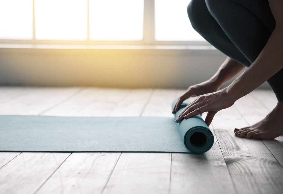 person unrolling yoga mat