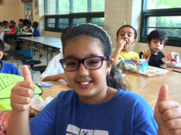 Female Charles Barrett student giving two thumbs up