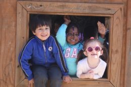 kids peaking out from outdoor play structure