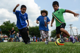 three boys playing soccer