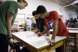 Titans Robotics Club at work standing around a table.