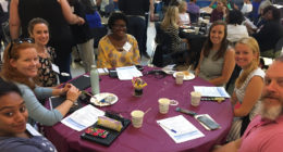 New teachers sitting around table at new teacher orientation