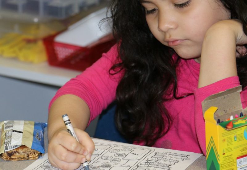 female student coloring at desk