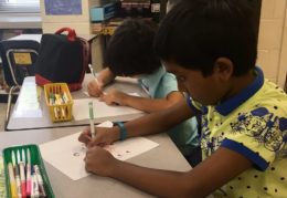 Two male elementary school students working at their desk