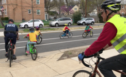 Students riding bikes accompanies by policeman and volunteers