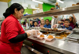 cateria worker serving kids in line