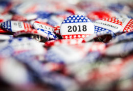 A 2018 Election Vote button on a pile of other buttons