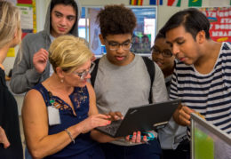 students with teacher and Chromebook