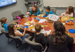 Students sit around a table and discuss qualities they'd like to see in their new school