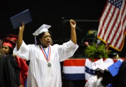 TC graduate in celebratory pose at graduation ceremony