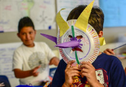 boy holding mask over face