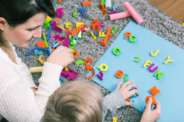 teacher and student working with letters