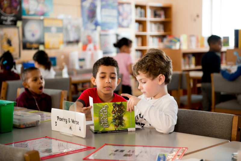 elementary school boys reading books at table