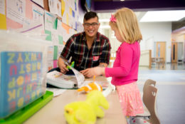 teacher working with elementary student