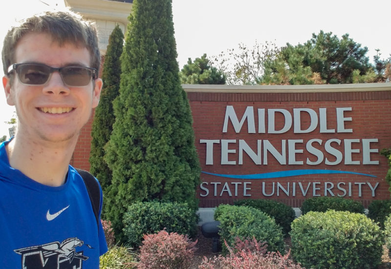 student standing in front of Middle Tennessee State University sign