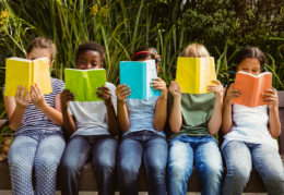 children on a bench reading books