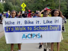 Students holding "walk to school" banner as they walk to school