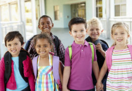 six smiling children holding hands