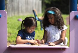 two young girls making mud pies