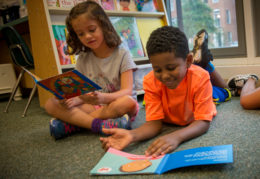 Two Tucker students reading on floor